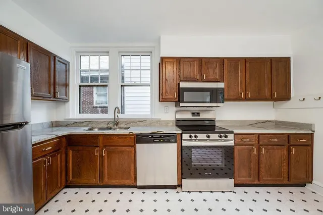 a kitchen with granite countertop a stove top oven microwave and cabinets