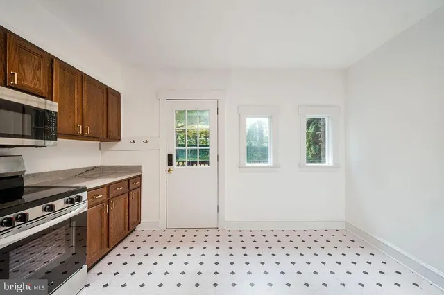 a kitchen with granite countertop a refrigerator stove top oven and sink