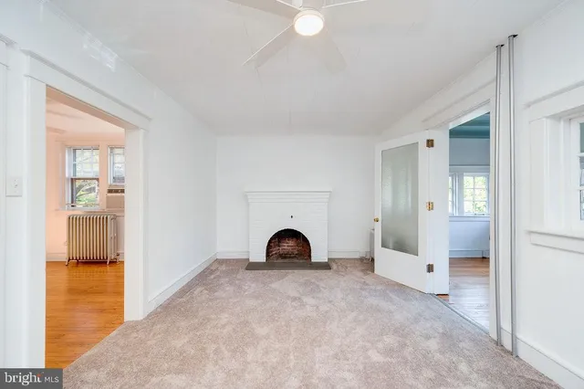 an empty room with fireplace and window