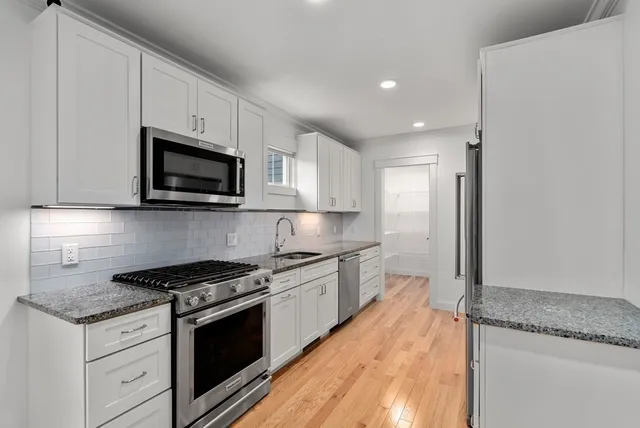a kitchen with granite countertop a stove top oven and sink
