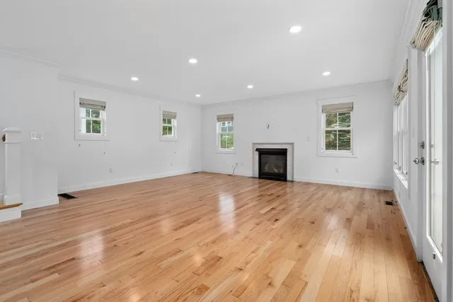 a view of empty room with wooden floor and fireplace