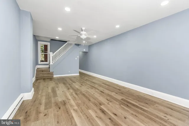 an empty room with wooden floor and entryway