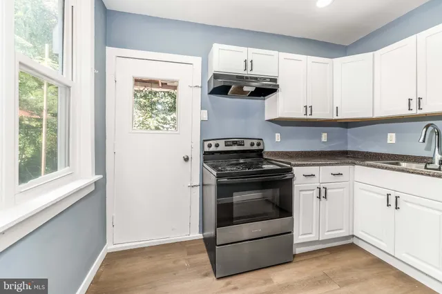 a kitchen with white cabinets and appliances