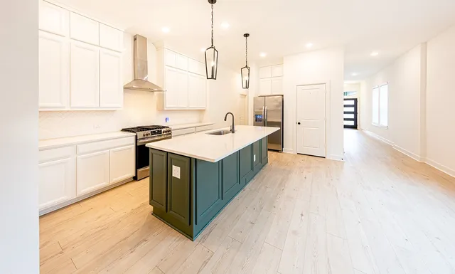 a kitchen with a stove a sink a refrigerator and a counter top space