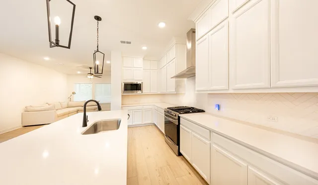 a kitchen with a sink a stove and cabinets