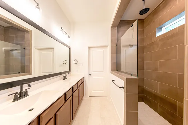 a bathroom with a double vanity sink a mirror and a shower