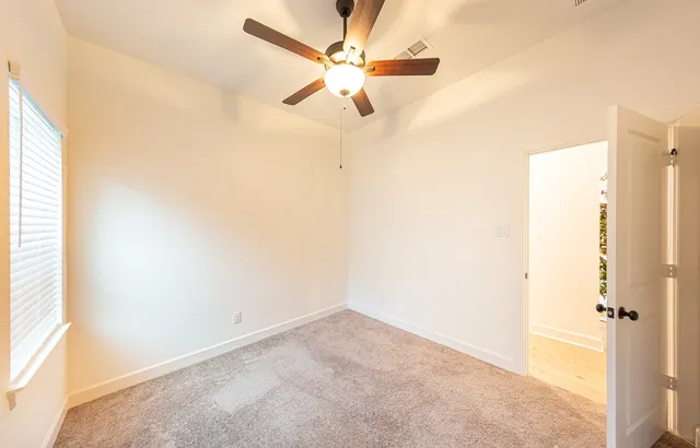 a view of a room with a ceiling fan and a window