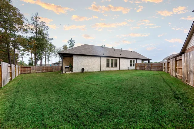 a view of a house with backyard and garden