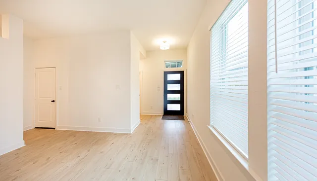 a view of a hallway with wooden floor and staircase