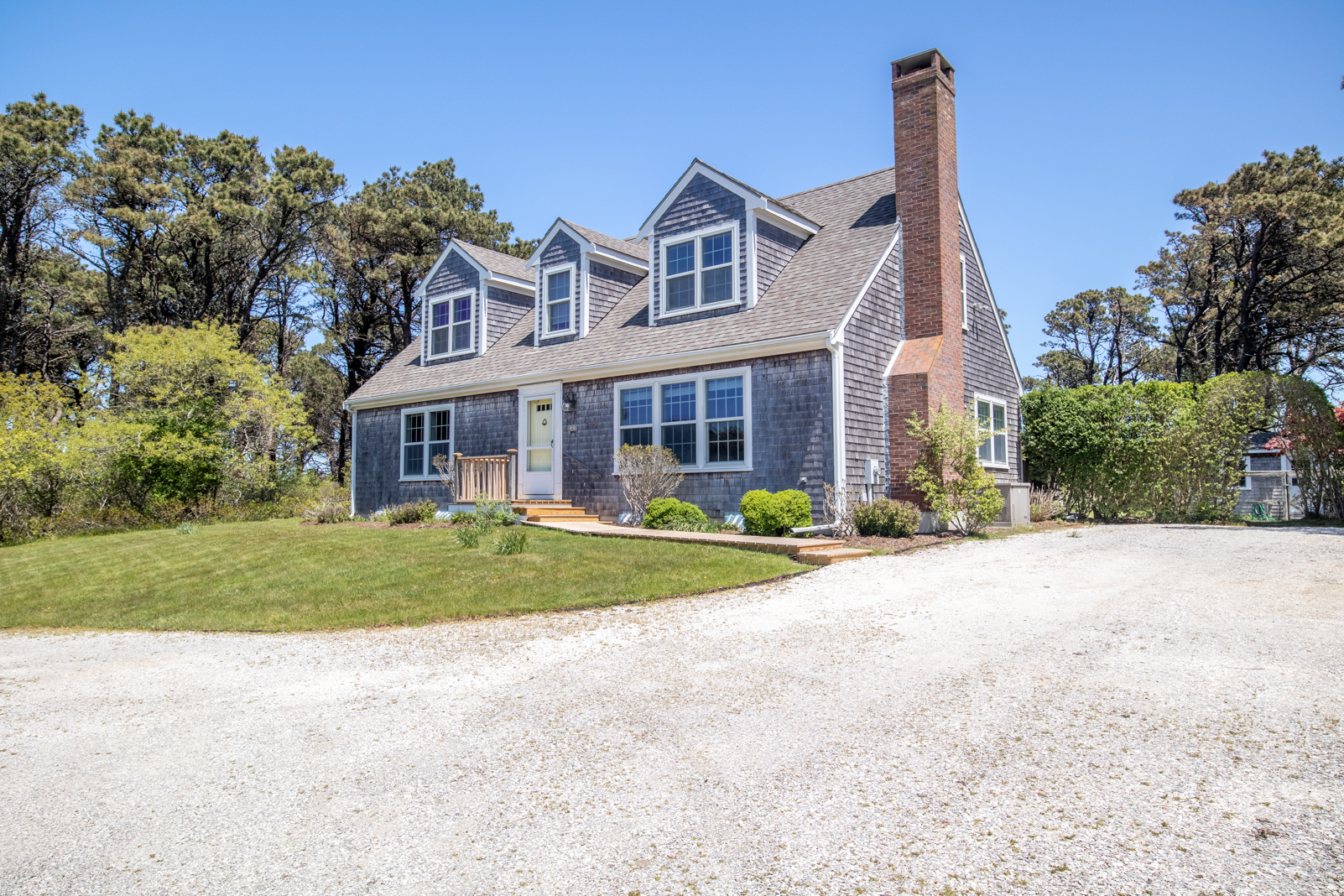 15 Swift Rock Road Nantucket, MA 02554 - Photo 5 of 32 a front view of a house with a yard and trees