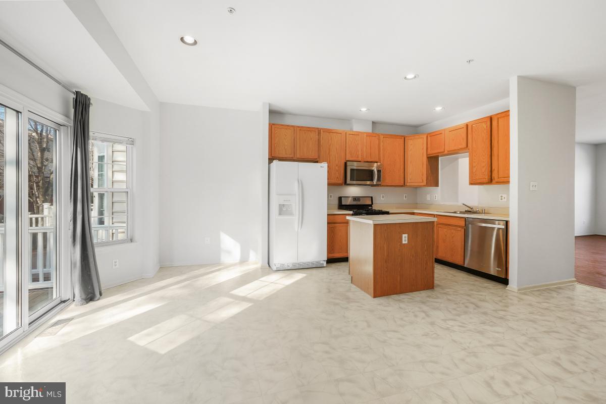 6334 Wind Rider Way Columbia, MD 21045 - Photo 22 of 45 a kitchen with stainless steel appliances a refrigerator a sink a stove top oven a counter space and cabinets