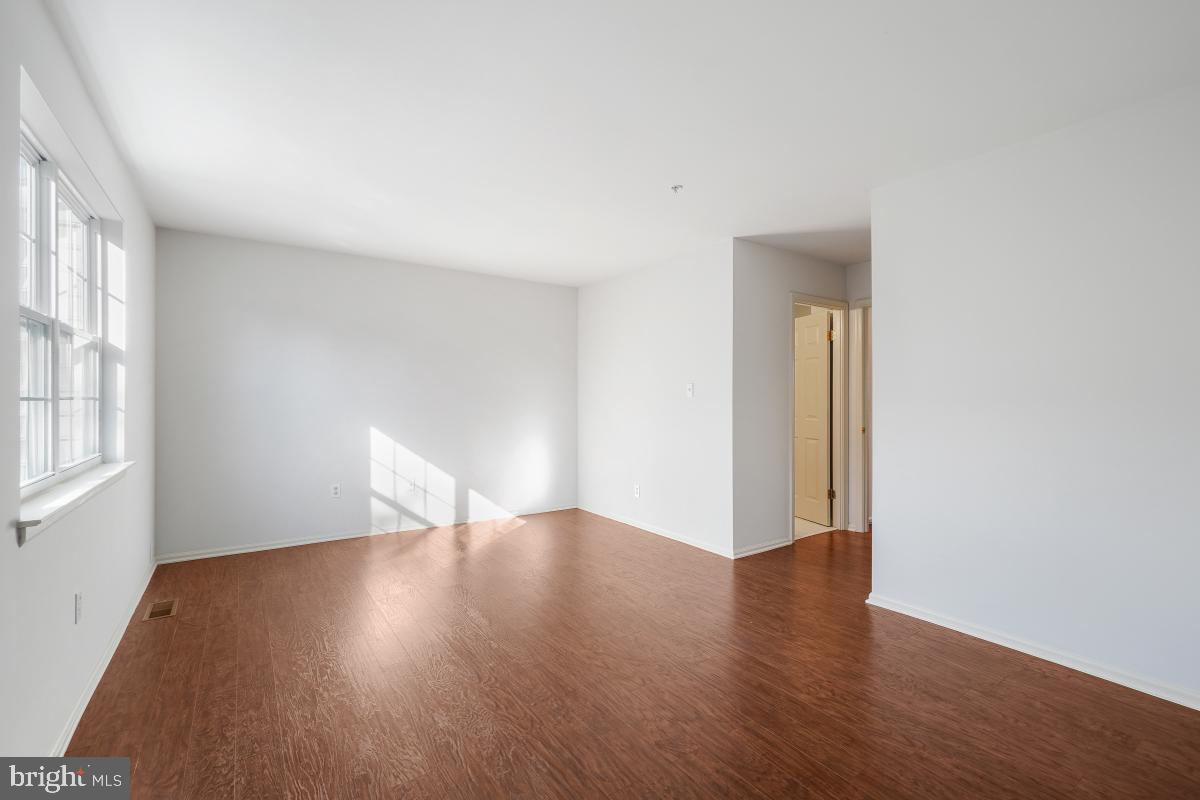 6334 Wind Rider Way Columbia, MD 21045 - Photo 33 of 45 a view of an empty room with wooden floor and a window