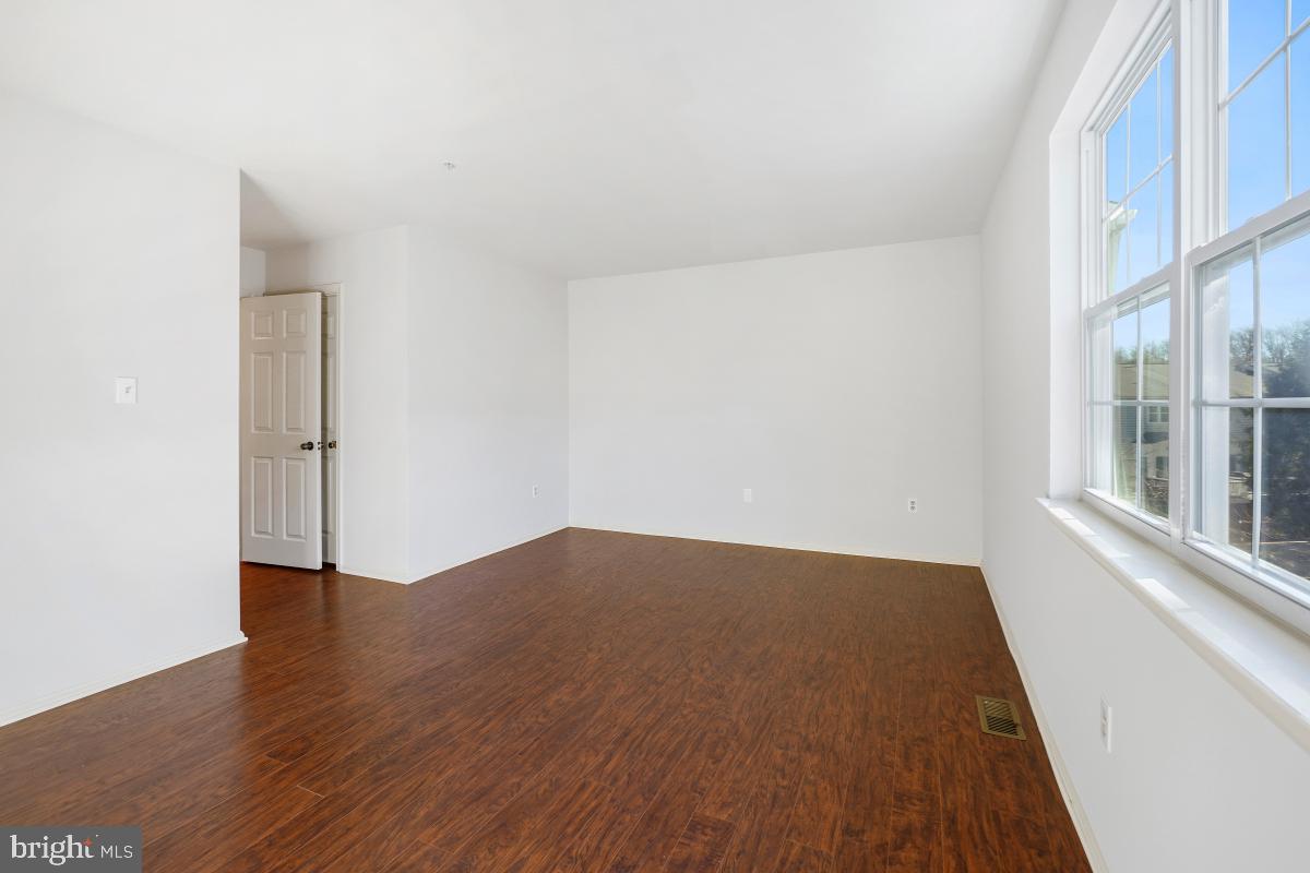 6334 Wind Rider Way Columbia, MD 21045 - Photo 34 of 45 an empty room with wooden floor and windows