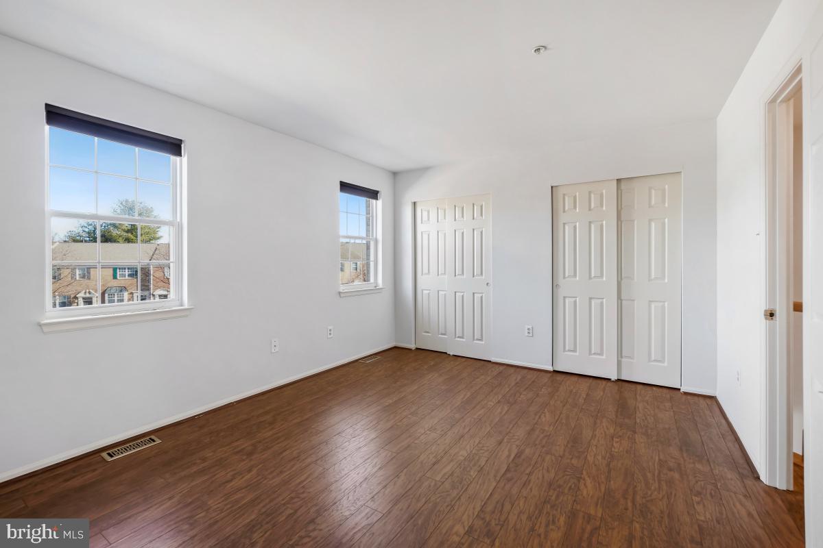 6334 Wind Rider Way Columbia, MD 21045 - Photo 39 of 45 a view of an empty room with wooden floor and a window