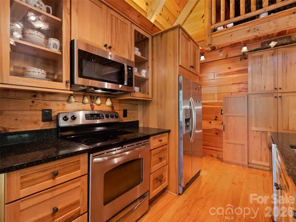 a kitchen with stainless steel appliances a stove a microwave and wood floor