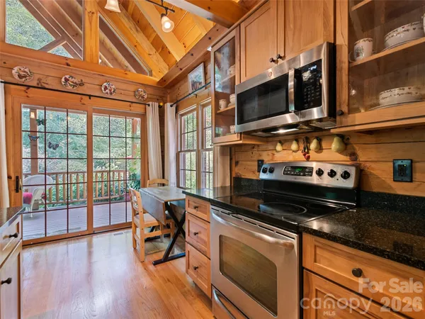 a kitchen with stainless steel appliances kitchen island granite countertop a stove and a wooden cabinets