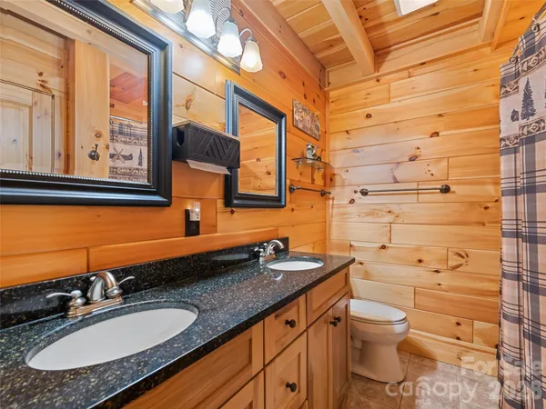 a bathroom with a granite countertop sink toilet and mirror