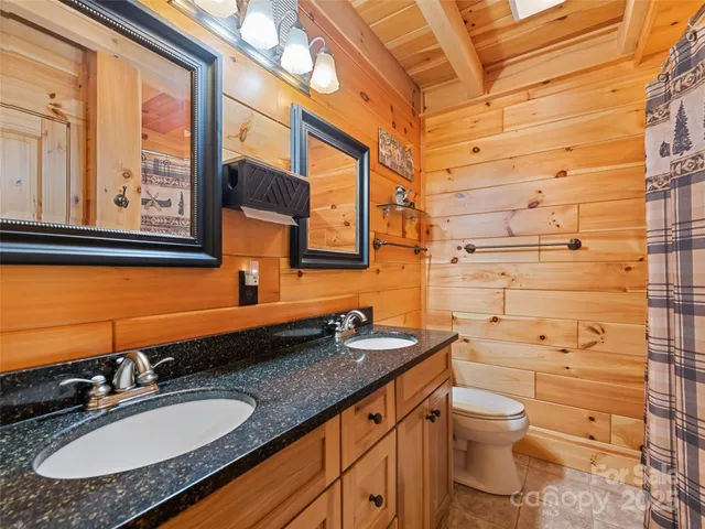 a bathroom with a granite countertop sink toilet and mirror