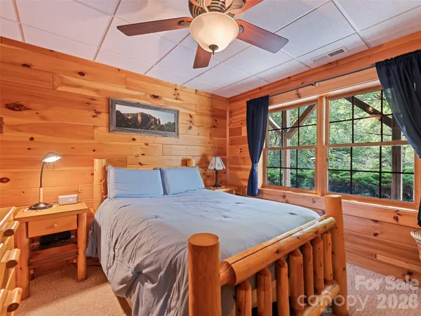a bedroom with a bed and large windows