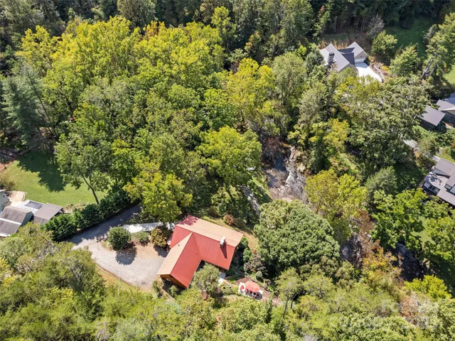 an aerial view of a house with a yard and lake view