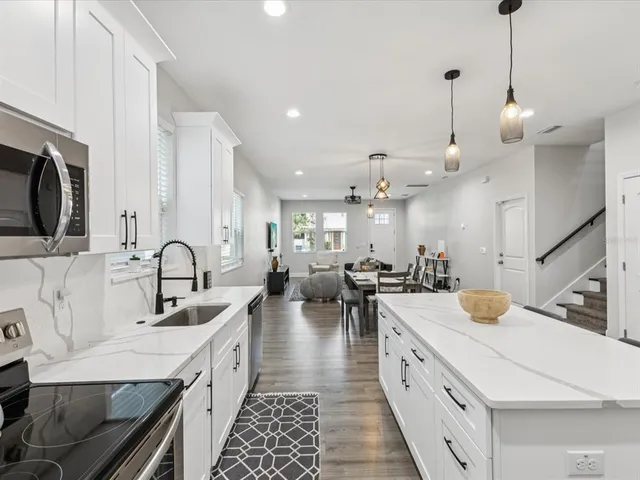 a large kitchen with stainless steel appliances kitchen island granite countertop a sink dishwasher a stove and a stove with wooden floor