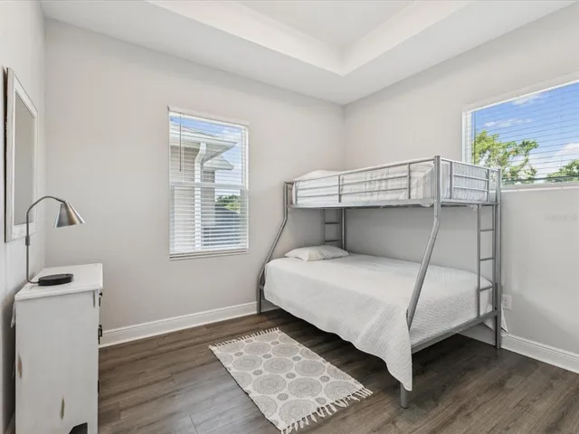 a bedroom with a bed and wooden floor