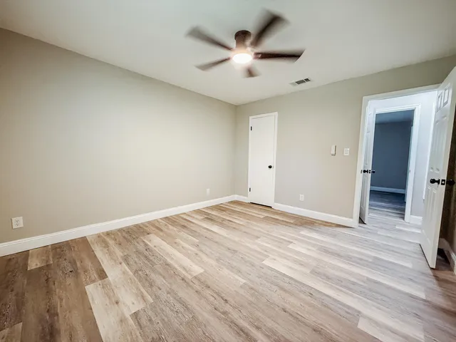 a view of empty room with wooden floor