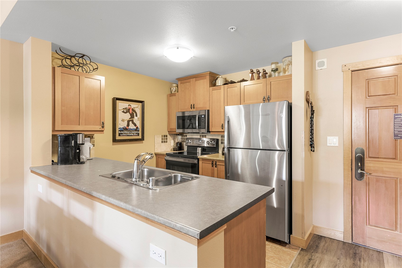 910 Copper Road, Unit 219 Copper Mountain, CO 80443 - Photo 6 of 35 a kitchen with stainless steel appliances granite countertop a refrigerator a sink a stove a dining table and chairs