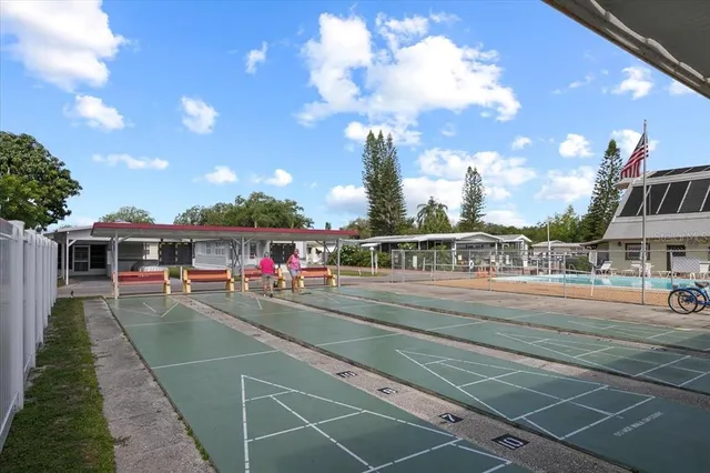 a view of a tennis ground with large trees