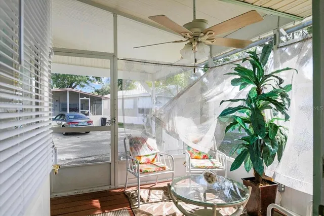 a view of a living room with a floor to ceiling window and potted plants
