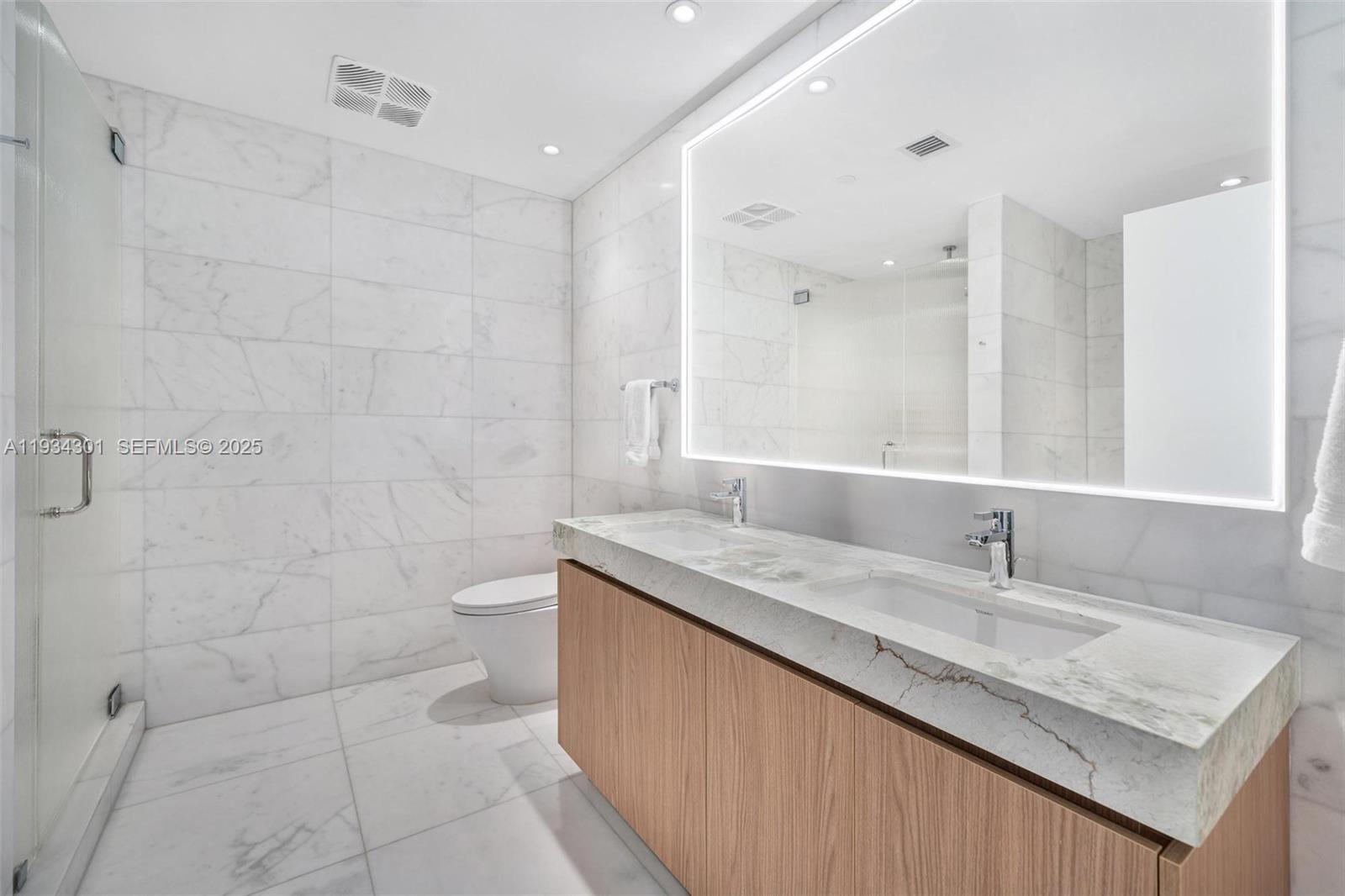 500 Alton Road, Unit 1602 Miami Beach, FL 33139 - Photo 13 of 33 a bathroom with a granite countertop sink a toilet and a mirror