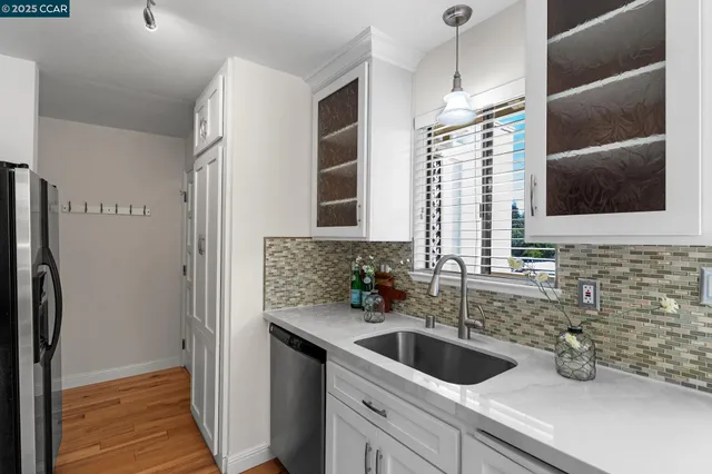 an empty room with wooden floor chandelier fan and entryway