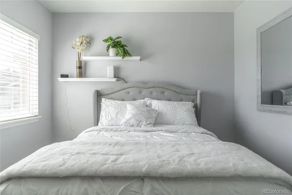 a bedroom with a bed flowerpot and window