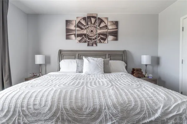 a bedroom with a bed and painting on the wall