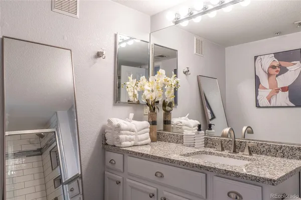 a bathroom with a granite countertop sink and a mirror