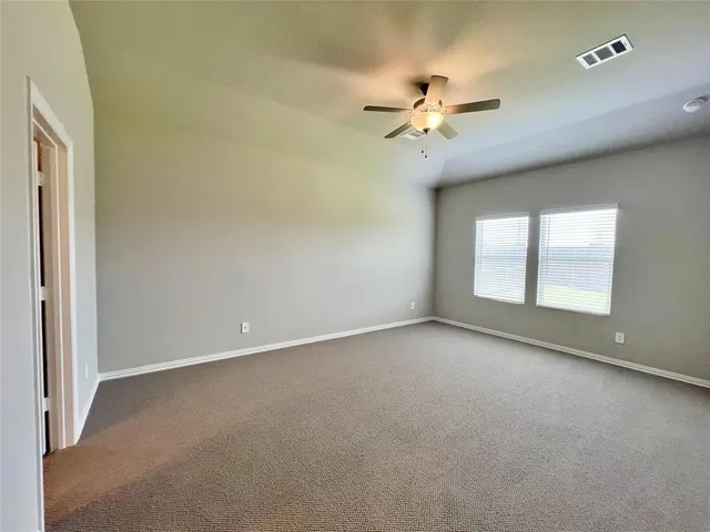 an empty room with windows and fan