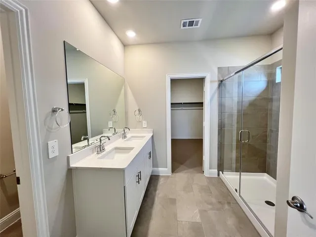 a en suite bathroom with a double vanity sink and a mirror