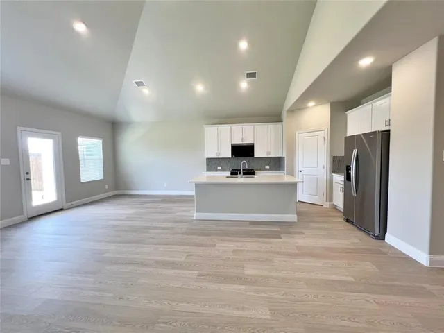 a kitchen with a refrigerator and a stove top oven