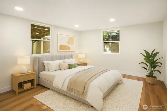 a bedroom with a large bed and a potted plant