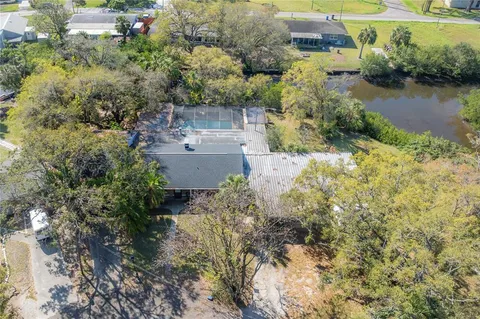 an aerial view of a house with a yard and lake view