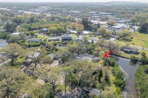 an aerial view of residential houses with city and green space