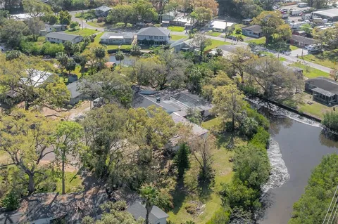 an aerial view of residential houses with outdoor space and trees