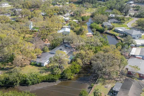 an aerial view of residential house with outdoor space and trees all around