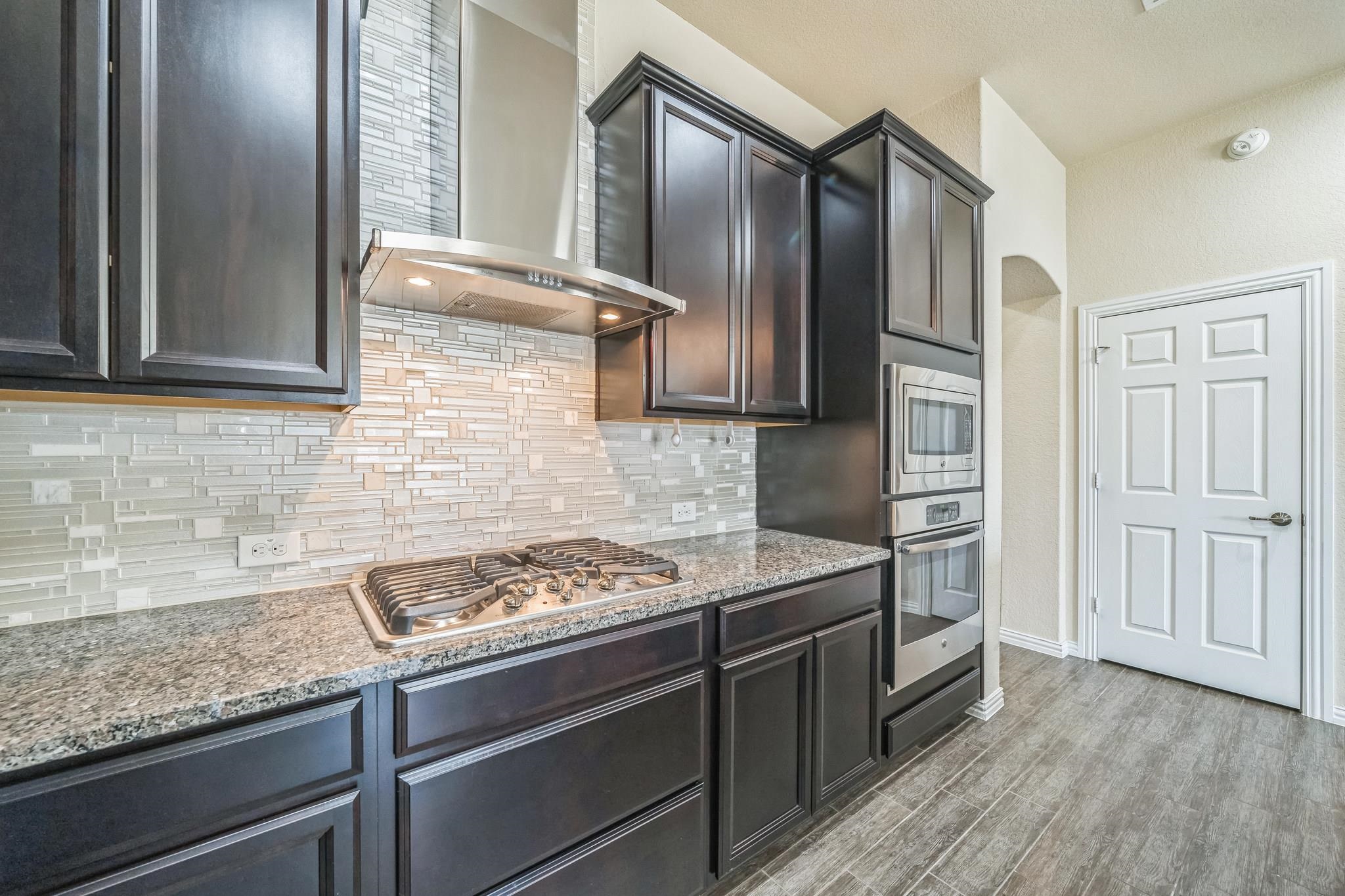 12009 Vignette Schertz, TX 78154 - Photo 11 of 40 a kitchen with stainless steel appliances granite countertop a refrigerator and a stove