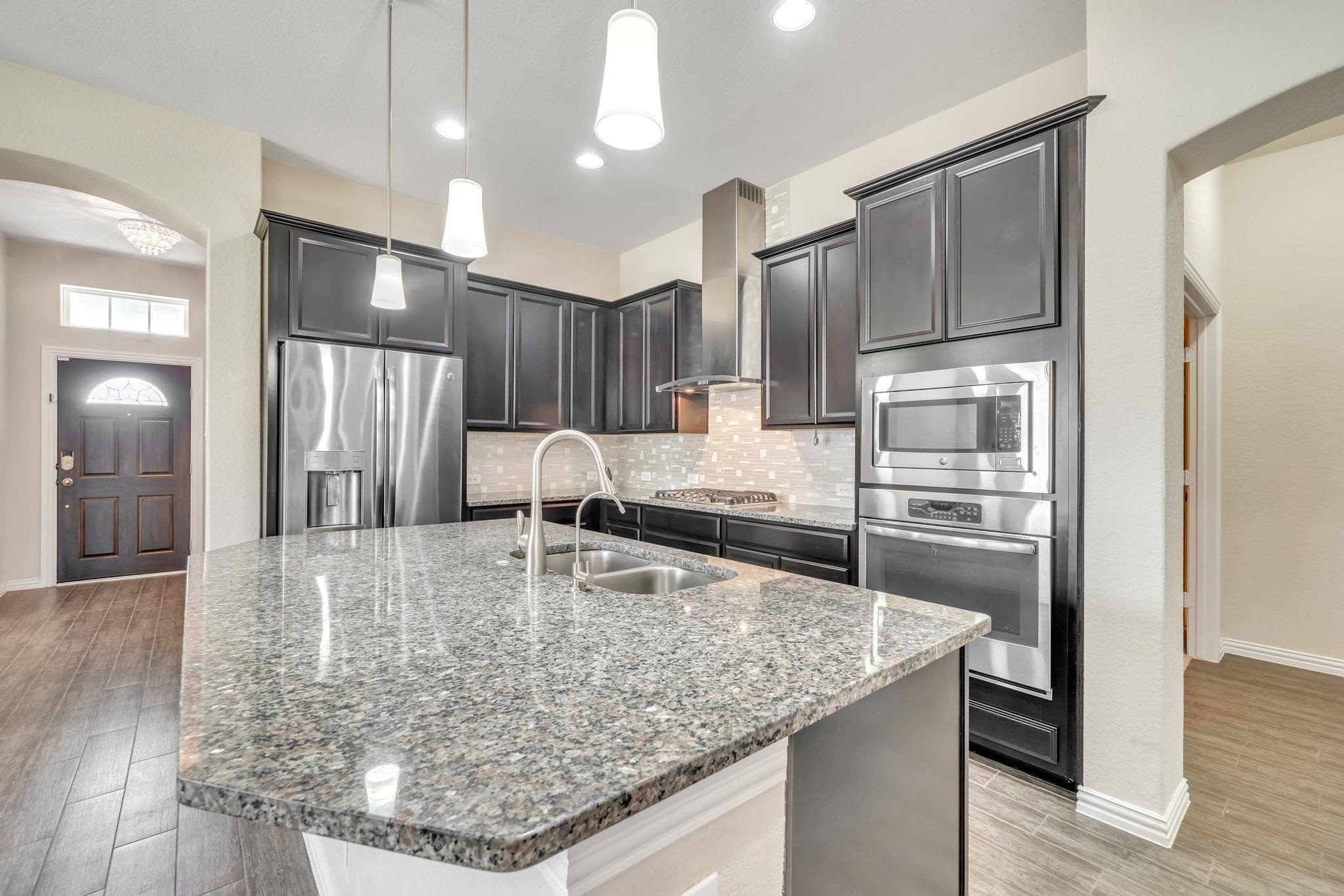 12009 Vignette Schertz, TX 78154 - Photo 12 of 40 a kitchen with stainless steel appliances granite countertop a refrigerator and a stove top oven