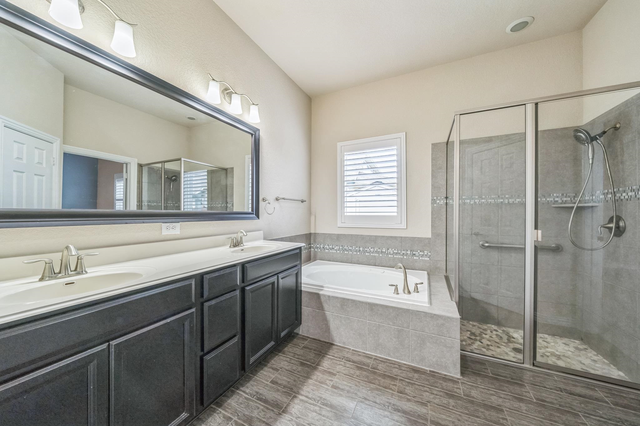 12009 Vignette Schertz, TX 78154 - Photo 20 of 40 a bathroom with a tub a sink and mirror