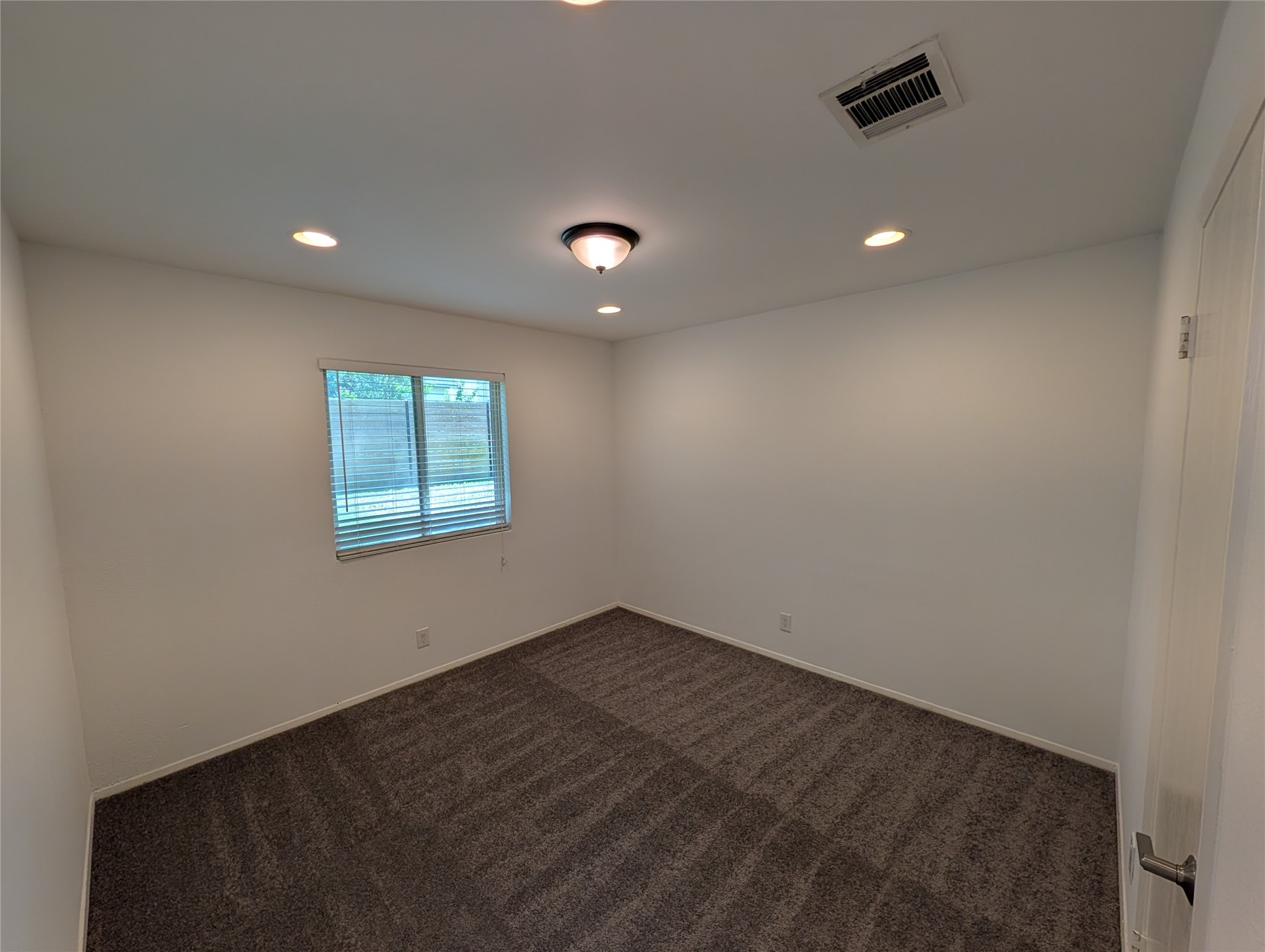 4601 Tamarack Trail Austin, TX 78727 - Photo 13 of 19 A well-lit bedroom with fresh carpeting and a large window offers a serene personal retreat.