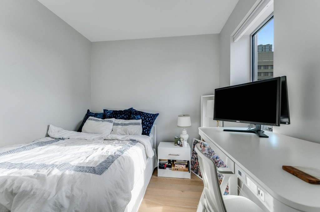 100 Shawmut, Unit 411 Boston, MA 02118 - Photo 11 of 15 a bedroom with a bed and a flat screen tv