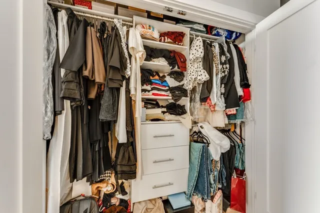 a view of walk in closet with clothes and shoes