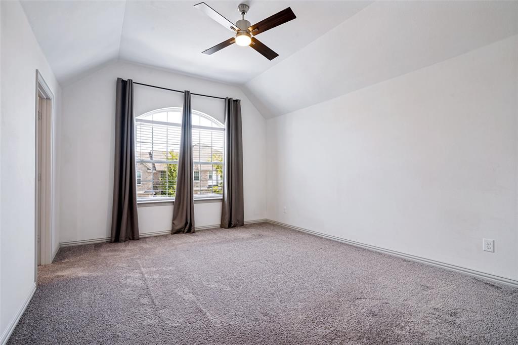 1006 Emil Place Allen, TX 75013 - Photo 15 of 28 Spacious room featuring vaulted ceilings, a large arched window with blinds, a ceiling fan, and carpeted flooring